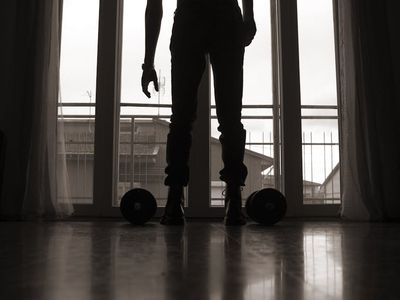 A person looking out a window at sunrise, feeling energized and ready for the day.