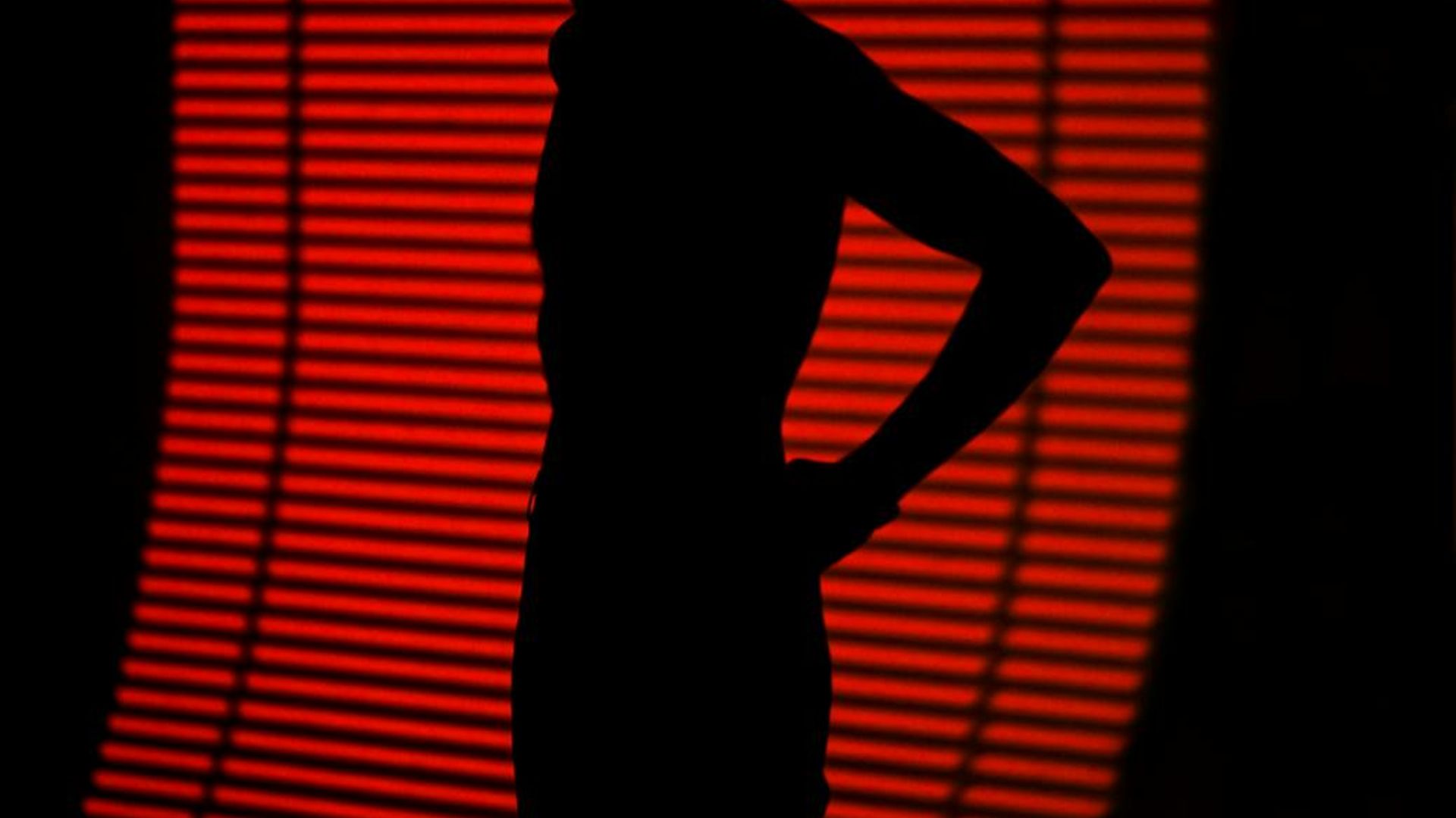 Abstract silhouette of a person in motion against a dark, minimalist background.